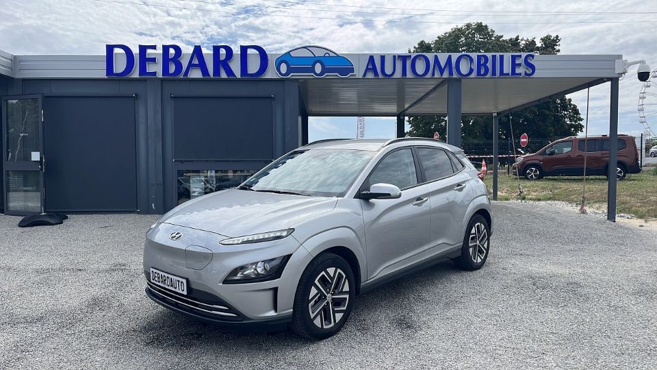 Hyundai Kona Electric grise de 2022 devant une agence Debard Automobiles