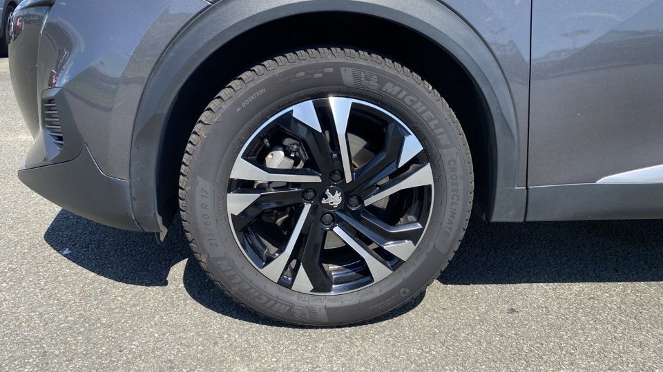 Roue avant d’une Peugeot 2008 grise avec jante alliage bicolore et pneu Michelin CrossClimate