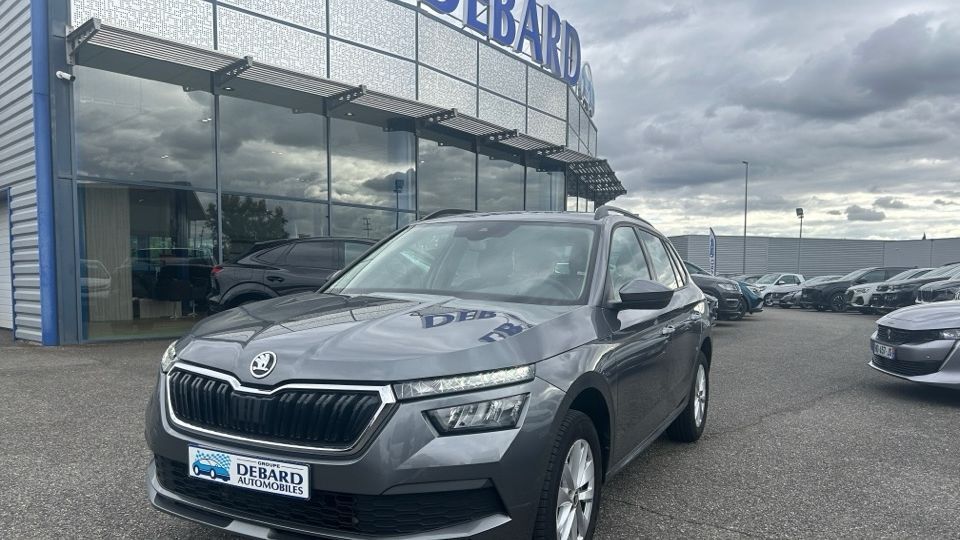 Skoda Kamiq 1.0 TSI 110 Ambition gris de 2023 devant une agence Debard Automobiles